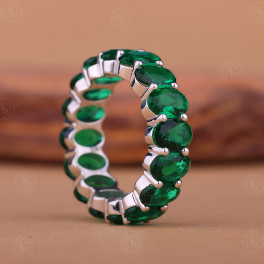 Oval green gemstone synthetic eternity wedding band in yellow gold